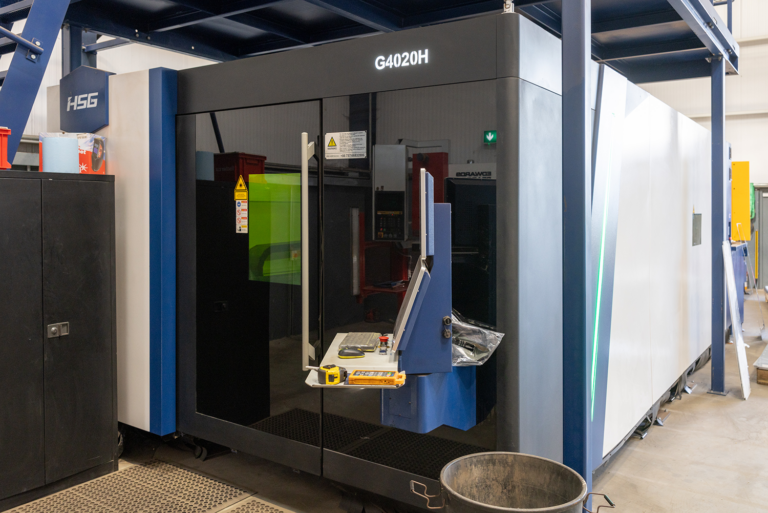 A big machine with a green and red inside.There is a blue attachment witha computer and mouse attached.