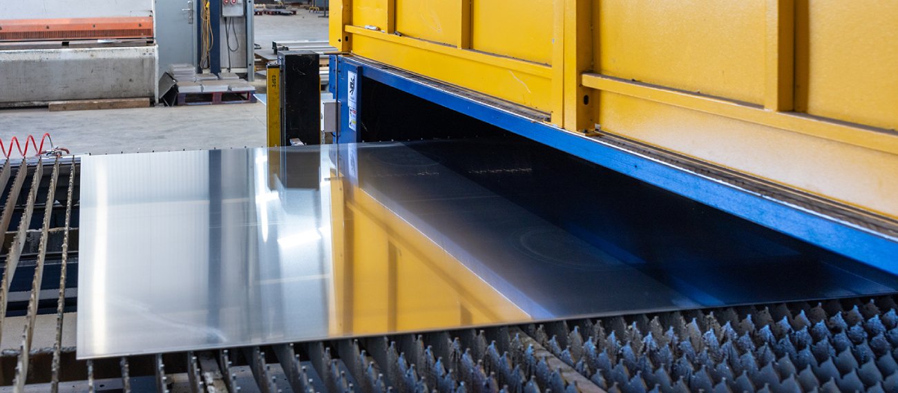 a large industrial machine on a conveyor belt going underneath a yellow machine
