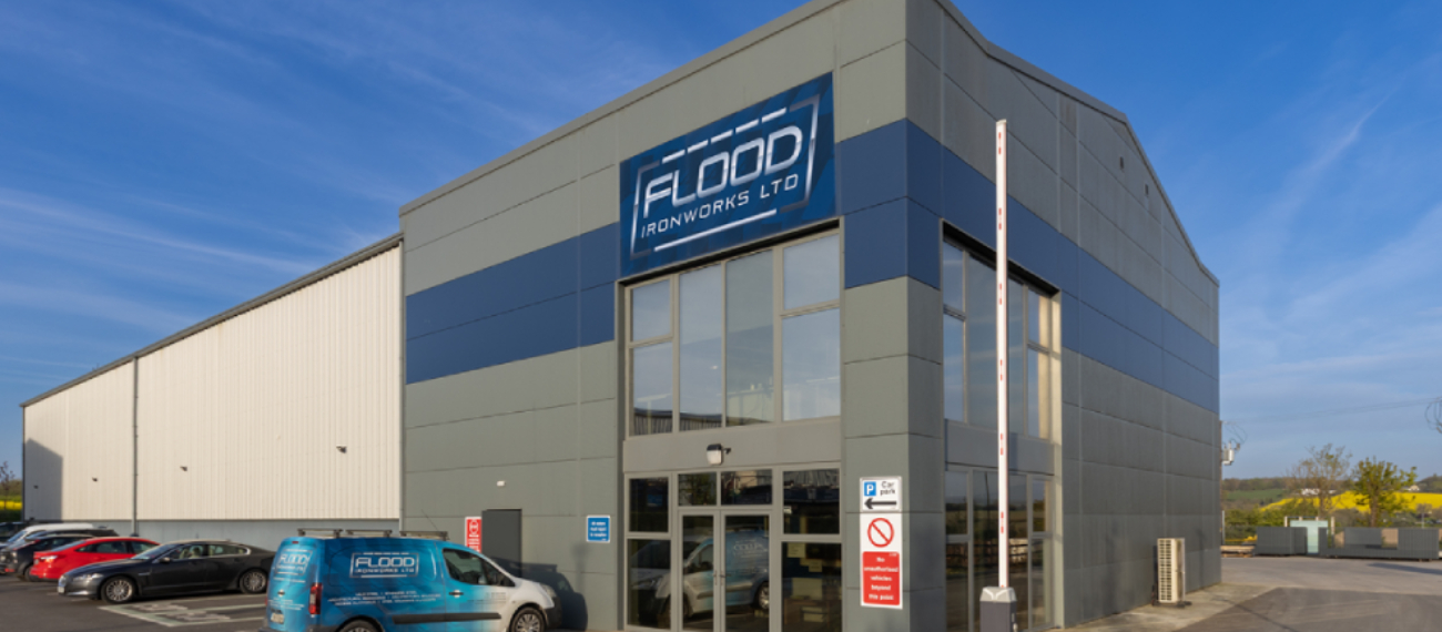 a dark grey building with a dark blue strip going across it horizontally and a sign that says flood ironworks ltd